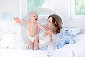 Mother and baby on a white bed