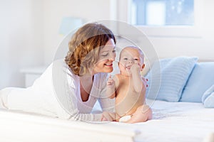 Mother and baby on a white bed