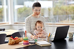 Mother with baby working at home office