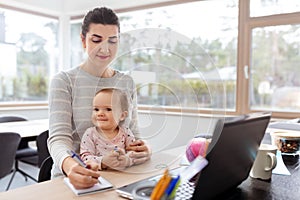 Mother with baby working at home office