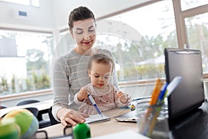 Mother with baby working at home office