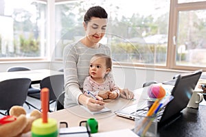 Mother with baby working at home office