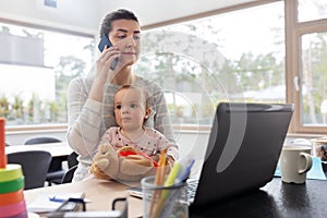 Mother with baby working on laptop at home office