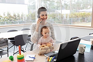 Mother with baby working on laptop at home office