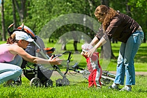 Mother and babysitter learn to walk baby.