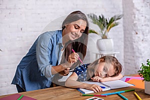 Mother becoming frustrated with daughter whilst doing homework sitting at the table at home in learning difficulties