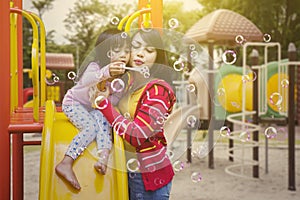 Mother blows soap bubbles with her daughter