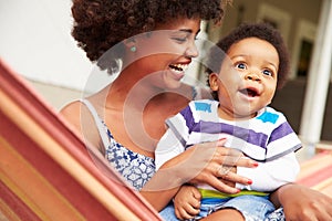 Mother bonding with young son sitting in a hammock