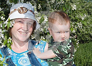 Mother and boy beside flowering aple tree photo