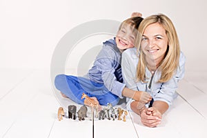 Mother and boy playing with toy animals