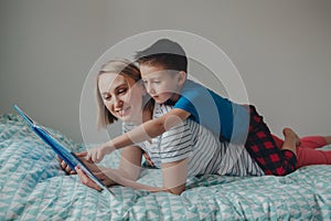 Mother and boy son at home reading book