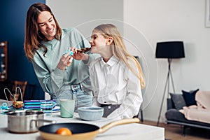 Mother braids her daughter's braids before school at breakfast