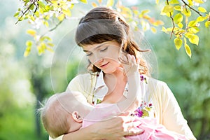 Mother breast feeding baby outdoors