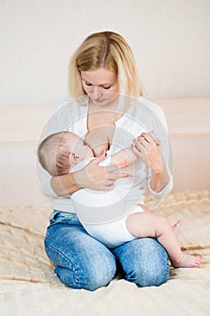 Mother breast feeding her infant baby indoors