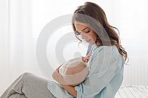 Mother breast feeding and hugging her baby boy