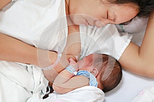 Mother breast feeding and hugging infant baby