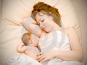 Mother is breast feeding newborn baby and dreami