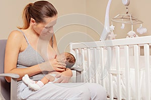 Mother breastfeed newborn infant baby sitting on the chair