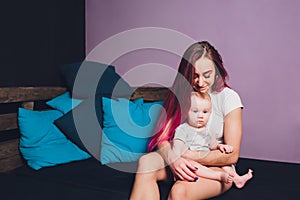 Mother breastfeeding baby in her arms at home. Beautiful mom Red hair breast feeding her newborn child. Young woman