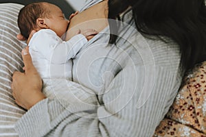 Mother breastfeeding her baby on the bed photo