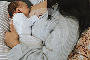 Mother breastfeeding her baby on the bed