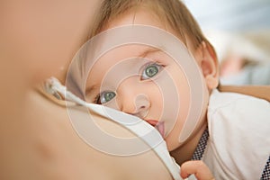 Mother is breastfeeding her baby at home. Mother breastfeeding baby in her arms at home