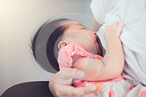 Mother breastfeeding her newborn baby girl.