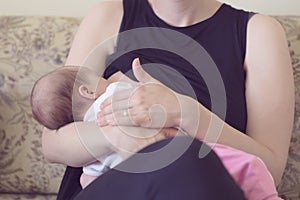 Mother breastfeeding her newborn baby girl