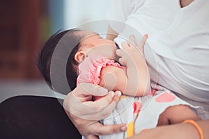 Mother breastfeeding her newborn baby girl.