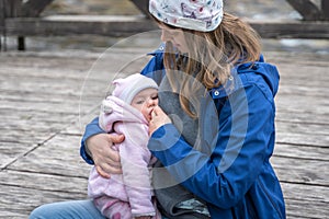 Mother breastfeeding her newborn baby girl in the park