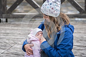 Mother breastfeeding her newborn baby girl in the park