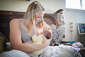 Mother breastfeeding her newborn baby at home after the hospital