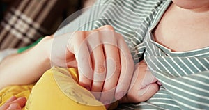 Mother breastfeeding her newborn baby on sofa. Milk from mother's breast is a natural medicine to baby. family, food