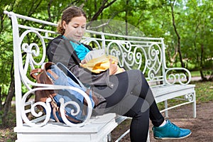 Mother breastfeeding infant and hush a baby to sleep when sitting on bench in urban park