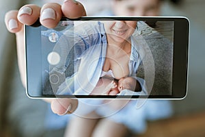 Mother breastfeeding mobile photo newborn baby