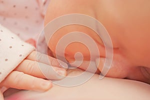 Mother breastfeeding newborn baby with breast milk