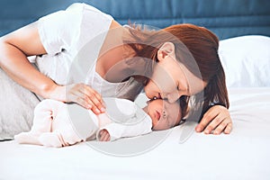 Mother breastfeeding newborn baby at home.