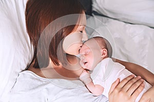 Mother breastfeeding newborn baby at home.