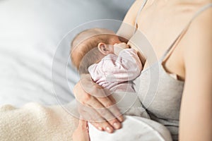 Mother breastfeeding newborn baby in room