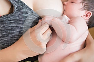 Mother breastfeeds baby. Mother breastfeeding her newborn baby beside window. Milk from mother`s breast is a natural medicine to