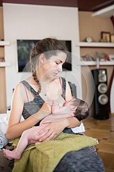 Mother breastfeeds baby. Mother breastfeeding her newborn baby beside window. Milk from mother`s breast is a natural medicine to