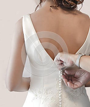 Mother buttoning wedding dress