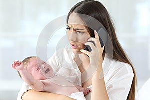 Mother calling to a doctor worried about her baby crying photo