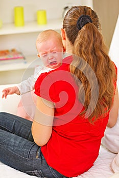 Mother calming crying baby photo