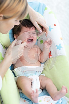 Mother calms newborn baby. Child is crying and screaming during colic