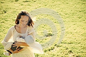 Mother care. Mother cuddle baby son on green grass