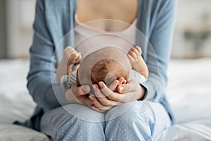 Mother Care. Unrecognizable mom holding newborn baby on her laps