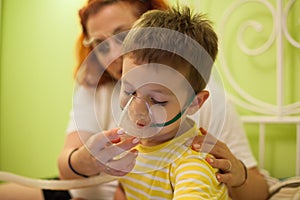 Mother caring kid with aerosols inhalation