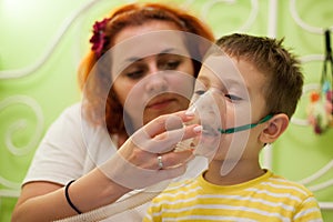 Mother caring kid with aerosols inhalation