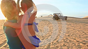 Mother Carries in Arms Small Girl on Dunes Shows Jeeps at Sunset